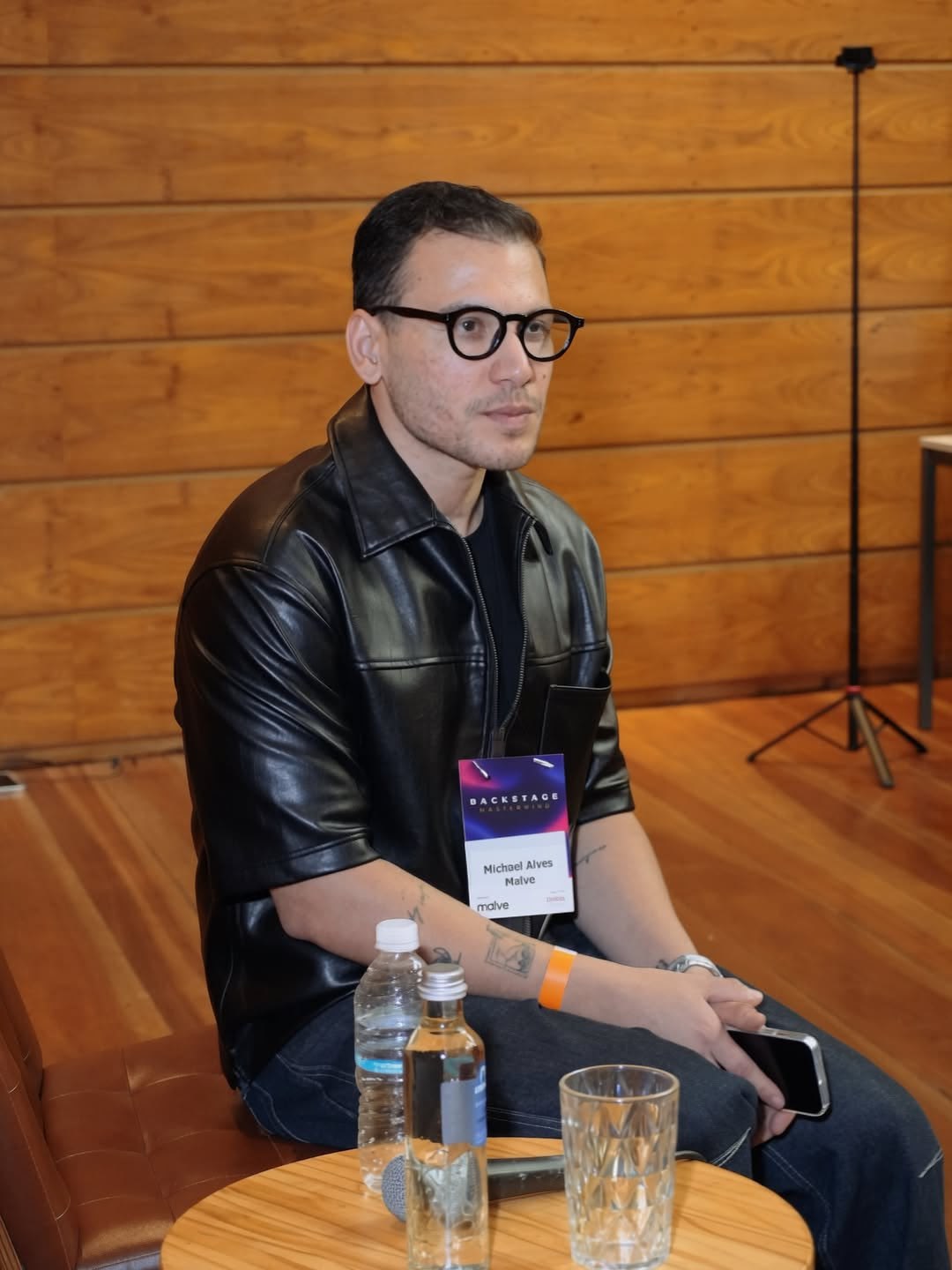 Michael Alves sentado no palco, com microfone, durante o Backstage Mastermind 2026.